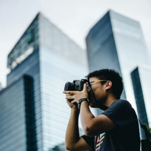 man wearing black t-shirt holding DSLR camera
